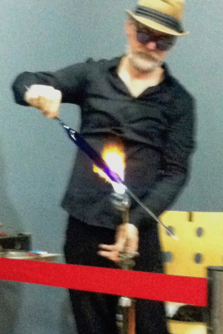 Mark Elliott blowing a glass instrument